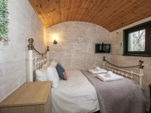 a bedroom with a bed with two towels on it at Aston - Shepherd Hut in Craven Arms
