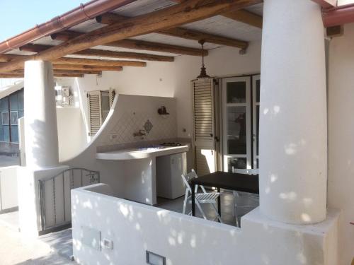 a kitchen and dining area of a house with white walls at Labottega home in Lipari