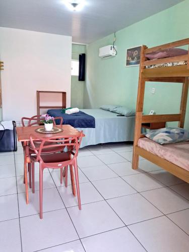 a room with a table and a bunk bed at Aguapé quarto 3 in Barreirinhas