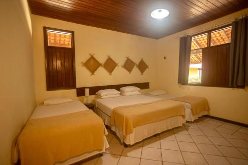 a bedroom with two beds in a room at Pousada dos Guarás in Salvaterra