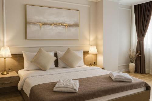 a bedroom with a large bed with two lamps at Mid Velvet Apartment, Free Parking, Self Check-in in Oradea