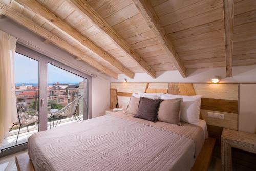 a bedroom with a large bed and a large window at Lena Apartments Potos Thassos in Potos
