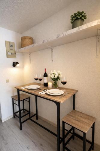 a table with two glasses of wine and flowers on it at Les Logis de Paray - app 124 in Paray-le-Monial