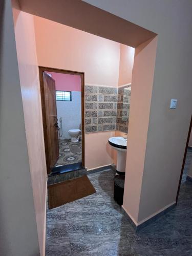 a bathroom with a toilet and a sink at HostelVK Gokarna in Gokarna