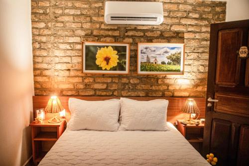 a bedroom with a bed and two night stands with lamps at A Flor Pousada in Garanhuns