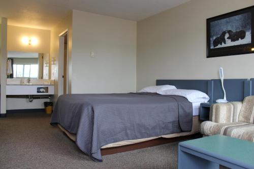 a hotel room with a bed and a couch at Plains Motor Inn in Stettler