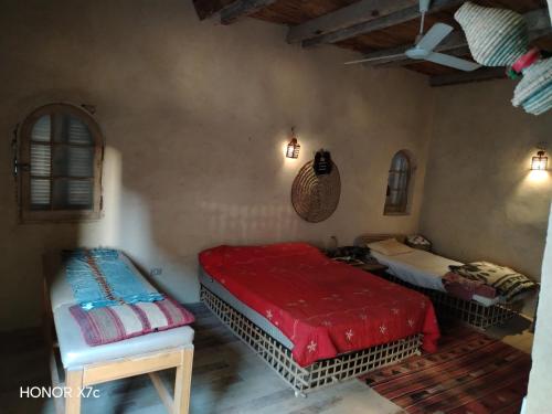 a bedroom with two beds and a red blanket at Siwa Shaly in Siwa