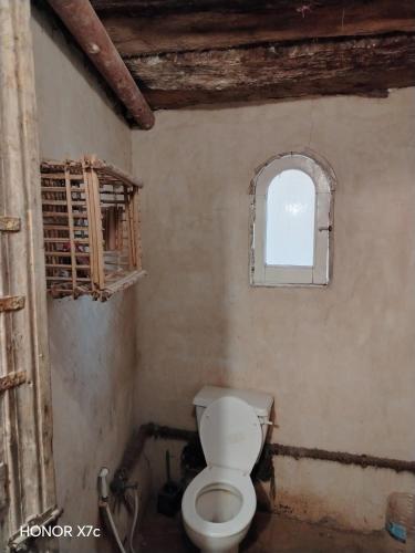 a bathroom with a toilet and a window at Siwa Shaly in Siwa