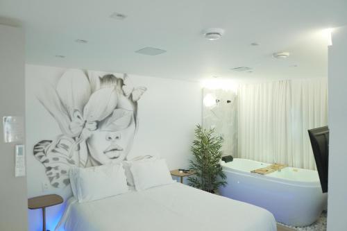 a bedroom with a white bed and a bath tub at Up Hotel Boutique in Bombinhas