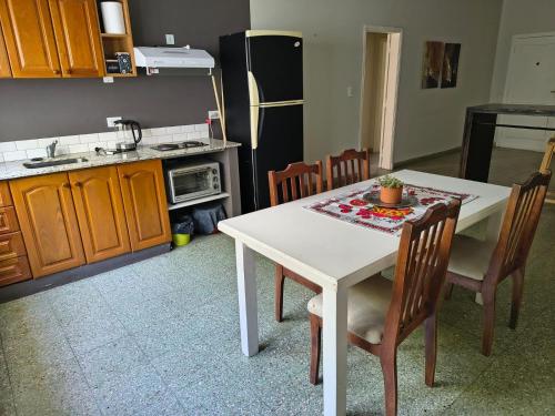 a kitchen with a table and chairs and a refrigerator at Lisboa in Chacabuco