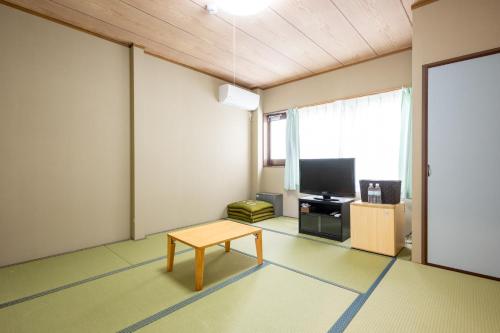 a living room with a table and a tv at Seaside house & Terrace SEAGULL - Vacation STAY 57577v in Towa
