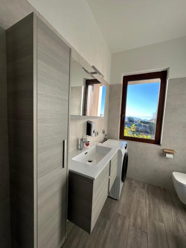 a bathroom with a sink and a window at Casa Rosetta in Tignale