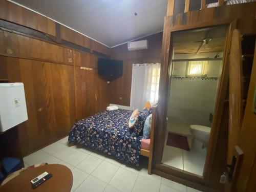 a bedroom with a bed and a bathroom with a toilet at Pousada Cantuá in Ilha do Mel