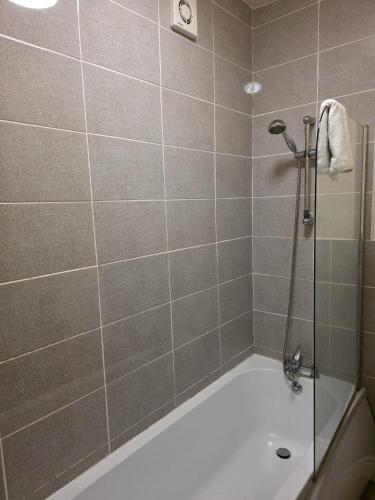 a bathroom with a shower and a bath tub at The Ormerod in Burnley