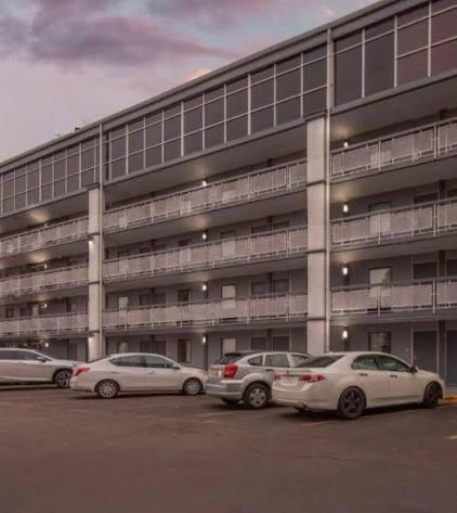 three cars parked in a parking lot in front of a building at Downtown Inn & Studio Suites in Memphis