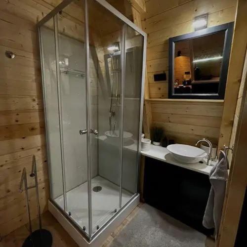 a bathroom with a glass shower and a sink at Bambusz-Kabin in Bárdudvarnok