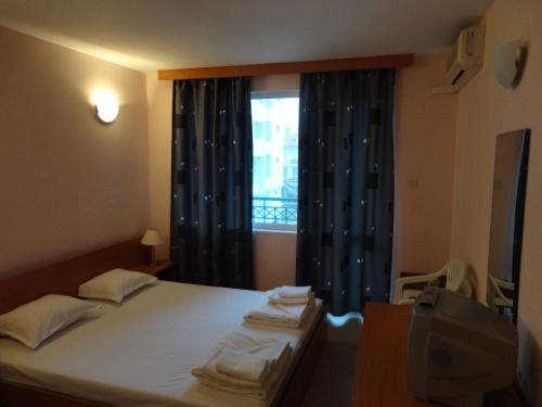 a bedroom with a bed and a window with curtains at Sargas Sozopol in Sozopol