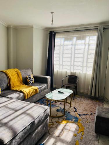 a living room with a couch and a table at T-Homes in Thika
