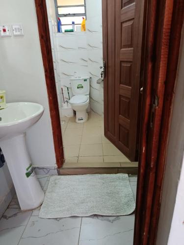 a bathroom with a toilet and a sink at T-Homes in Thika
