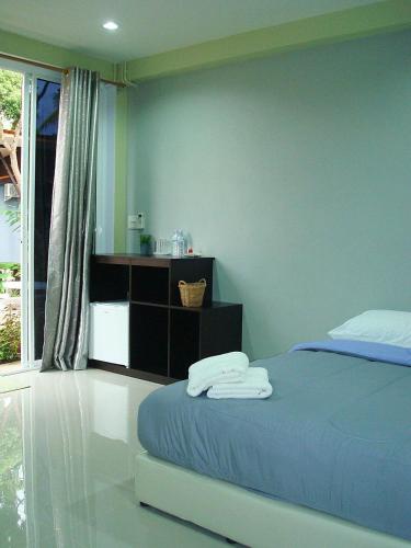 a bedroom with a bed with two towels on it at Meephawa Resort in Amphawa