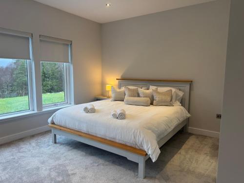 a bedroom with a large bed with two white pillows at MacGregor Ranch Apartment in Spean Bridge