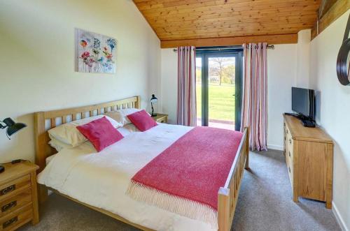 a bedroom with a large bed and a television at 1 Bed in Llandinam oc-waa376 in Llandinam