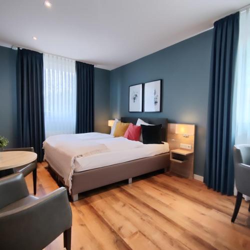 a bedroom with a bed and a table and chairs at Hotel Restaurant Verst in Gronau