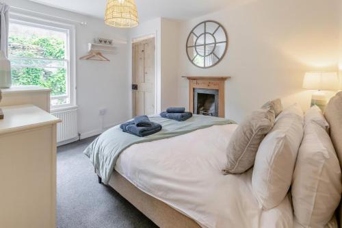 a bedroom with a large white bed with a fireplace at 2 Bed in Fowey oc-m29077 in Fowey