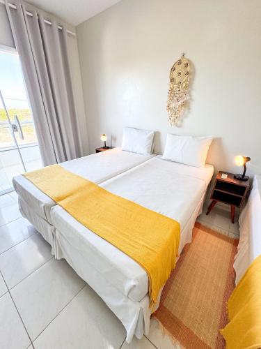 un dormitorio con una cama grande con una manta amarilla en Eficiência - Casa Dascli - Sua Casa em Camocim, en Camocim