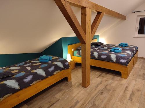 two twin beds in a room with wooden floors at Chez Netty Gite avec sauna à Beblenheim in Beblenheim