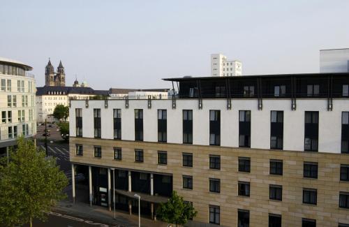 a white building with black windows in a city at Hotel Magdeburg City Center by Leonardo Hotels in Magdeburg