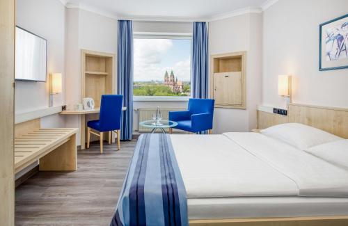 a hotel room with a bed and a table and chairs at Hotel Freiburg City Center by Leonardo Hotels in Freiburg im Breisgau