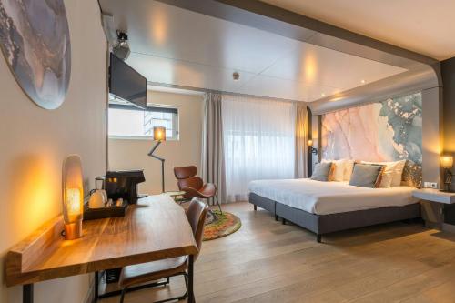 a hotel room with a bed and a desk at Leonardo Hotel Almere City Center in Almere