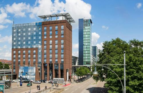 a tall building in the middle of a city at Hotel Freiburg City Center by Leonardo Hotels in Freiburg im Breisgau