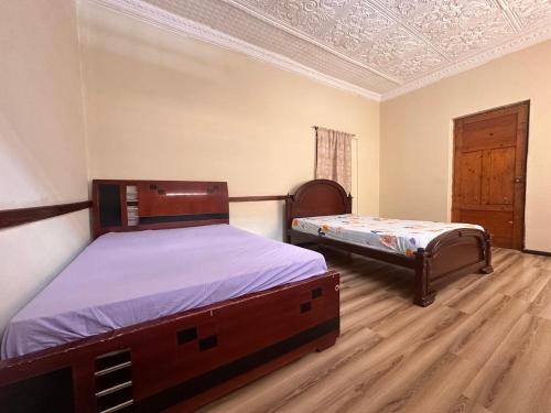 a bedroom with two twin beds and a ceiling at Albergue Happy Backpacker in Cuenca