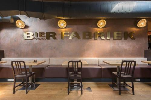 a bar with two chairs and a sign that reads beer fatigue at Leonardo Hotel Almere City Center in Almere