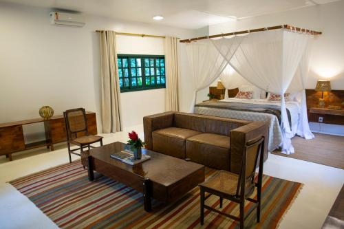 a bedroom with a bed and a couch and a table at Fazenda Shanti in Alto Paraíso de Goiás