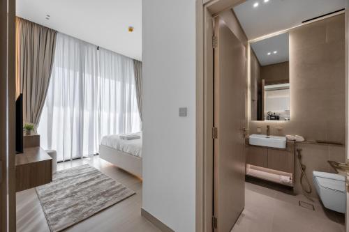 a bathroom with a sink and a bed and a mirror at Private Pool - Amazing 1BR Apartment in JVC in Dubai