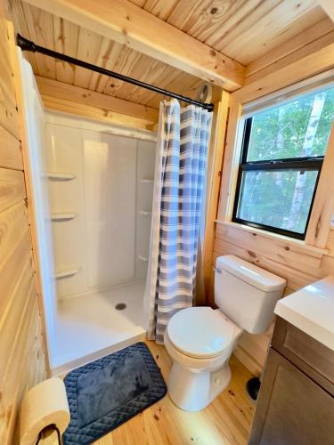 a small bathroom with a toilet and a shower at Cozy Coastal Cabin 3 in Steuben