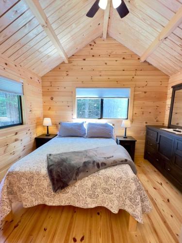 a bedroom with a bed in a wooden cabin at Cozy Coastal Cabin 3 in Steuben