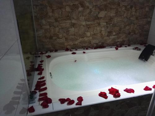 a bath tub filled with red roses in a bathroom at Gran Hotel Internacional Sanbara in Arauca