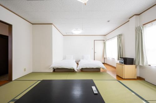 a bedroom with two beds and a carpet at Seaside house & Terrace SEAGULL - Vacation STAY 48168v in Towa