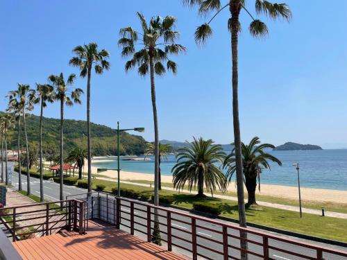 a view of a beach with palm trees and a fence at Seaside house & Terrace SEAGULL - Vacation STAY 48168v in Towa