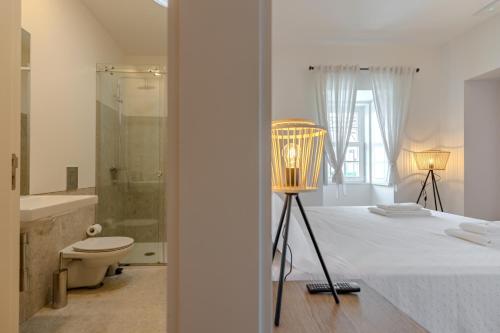 a bedroom with a bed with a lamp and a bathroom at Casa Da Brêa Viana do Castelo - Villa & Apartment in Viana do Castelo