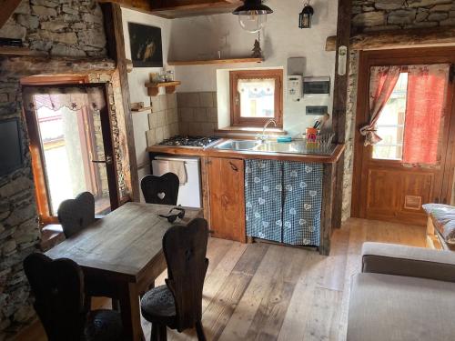 a kitchen with a wooden table and a sink at La Casetta Prali in Prali