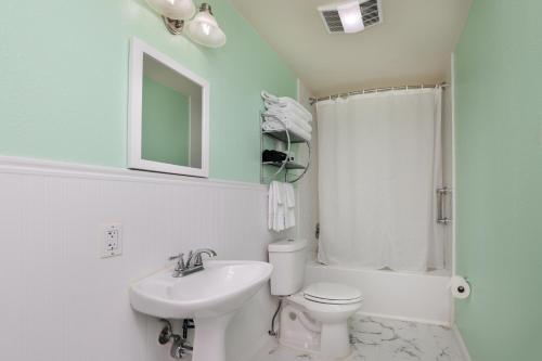 a bathroom with a sink and a toilet and a mirror at Inn On The River in Glen Rose
