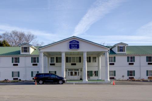a car parked in front of a white building at Plantation Inn & Suites Near Locust Grove I 75 in Jackson
