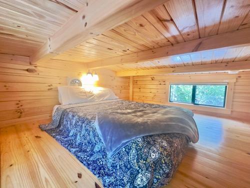 a bedroom with a bed in a wooden cabin at Cozy Coastal Cabin 4 in Steuben