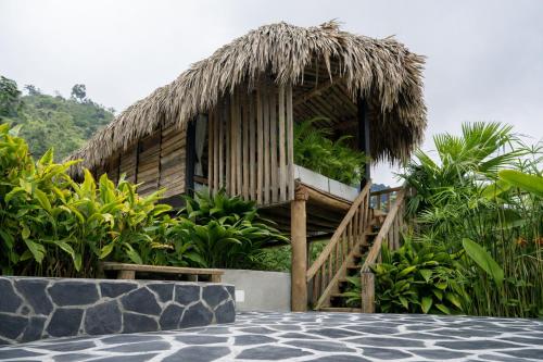 a resort building with a staircase and a grass roof at Eco Hotel Glamping El Silencio in Santa Rosa de Cabal