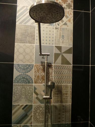 a shower in a bathroom with a tile wall at Bird Day Boutique Hotel in Mukdahan